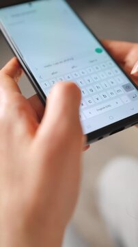 Female hands typing text on smartphone close-up.