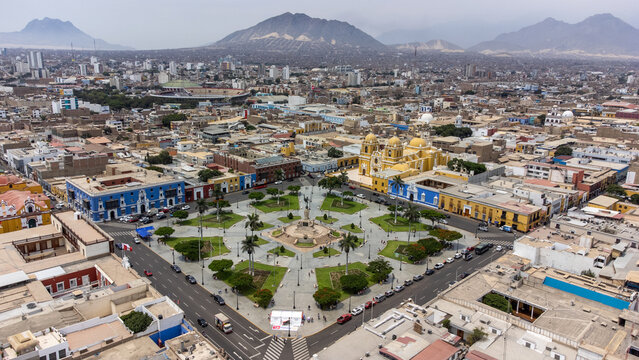 Aerial view of Plaza de Armas Trujillo with its central monument, colonial buildings, yellow cathedral, and palm trees in Trujillo, La Libertad, Peru.