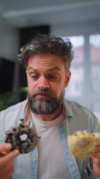 A man eating two donuts simultaneously with delight. Sugar addiction. Slow