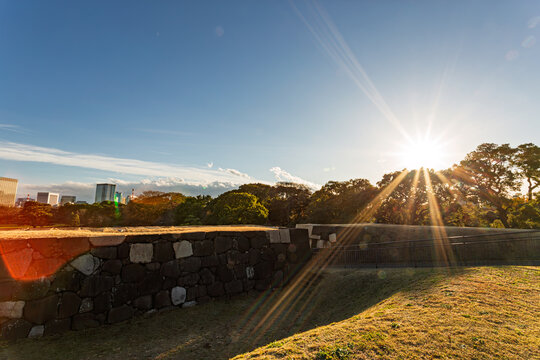 Dazzling sunbeams bursting over the grand stone wall of former Edo Castle at the Imperial Palace East Gardens December 2023