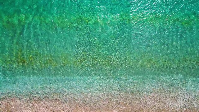 Top-down view of paradise pebble beach and crystal clear water. Rhodes, Greece