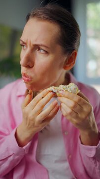 Woman with eating disorder eating a donut with a sense of guilt