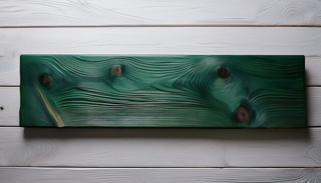 a smooth dark green stained wood plank rests on a white wood surface