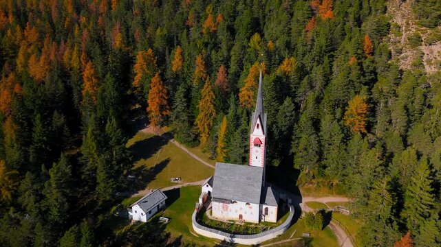 Church of St. Jacob and mountains on the background. Autumn in Dolomites, Italy.