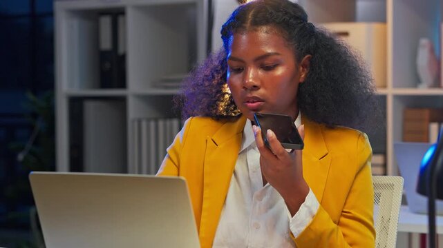 Black female business analyst using AI agent on laptop for strategic planning at night office, artificial intelligence assistant helping corporate decision making, future of work concept