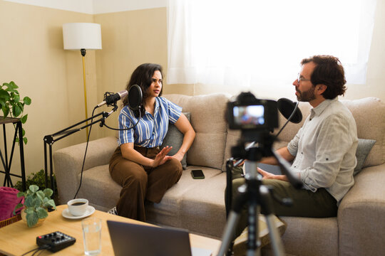 Hispanic podcasters recording interview, woman expressing disagreement during a live video streaming talk show