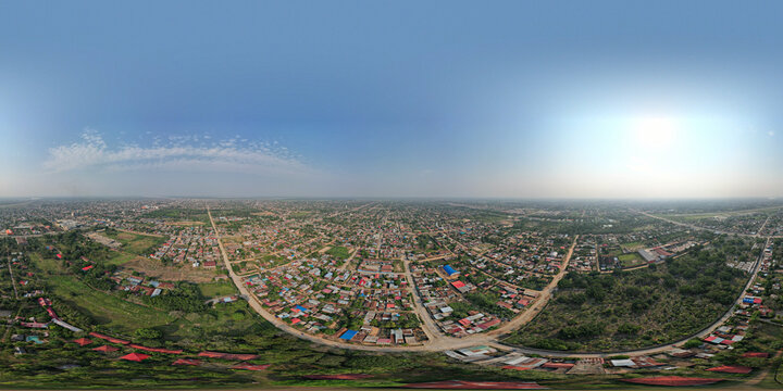 Aerial view of the sprawling city of Pucallpa with dense residential blocks, scattered buildings, and surrounding lush green vegetation in Pucallpa, Ucayali, Peru.
