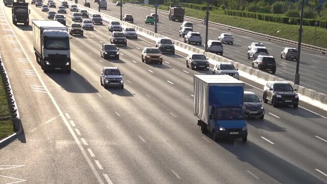 Moscow June 02 2026, Multiple vehicles travel on a multi-lane highway during daylight hours. Cars, trucks, and buses move steadily in separate lanes. The road is bordered by greenery on both sides