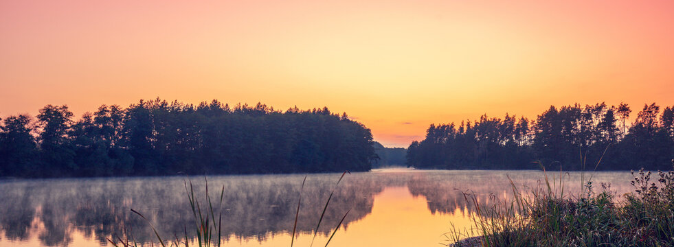 Magical dawn over the lake with a beautiful reflection on the water. Serene lake in the early morning. Nature landscape
