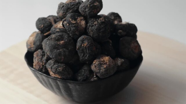 Black maca from Peru displayed on a wooden tray.