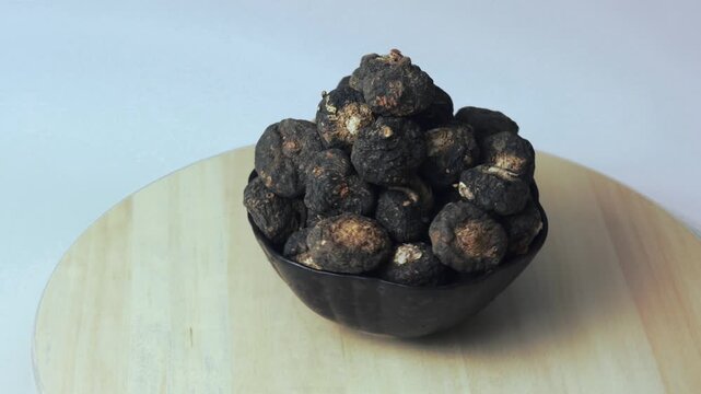 Bowl with black maca from the Peruvian Andes on a rotating tray.