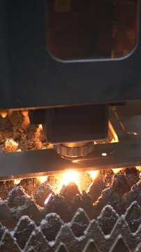 Industrial metal cutting operation by CNC laser machine. Sparks show speed and control. Concept of engineering technology and modern production