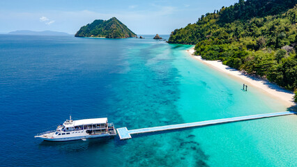 Aerial drone view of tropical landscape over Madam Beach of Nyaung Oo Phee Island with tour boat anchoring on the floating dock in the Mergui Archipelago, Myanmar. Beautiful Andaman sea in Burma © zephyr_p