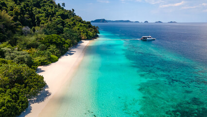 Aerial drone view of tropical landscape over Madam Beach of Nyaung Oo Phee Island with tour boat anchoring on the floating dock in the Mergui Archipelago, Myanmar. Beautiful Andaman sea in Burma © zephyr_p