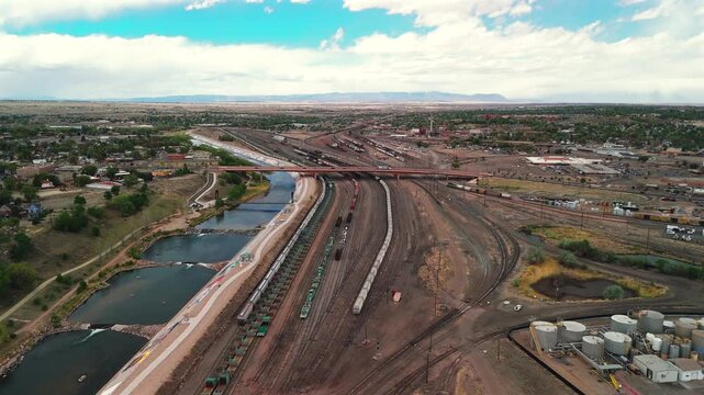 Aerial drone flies above major Pueblo Colorado rail yard following pattern of parallel freight lines