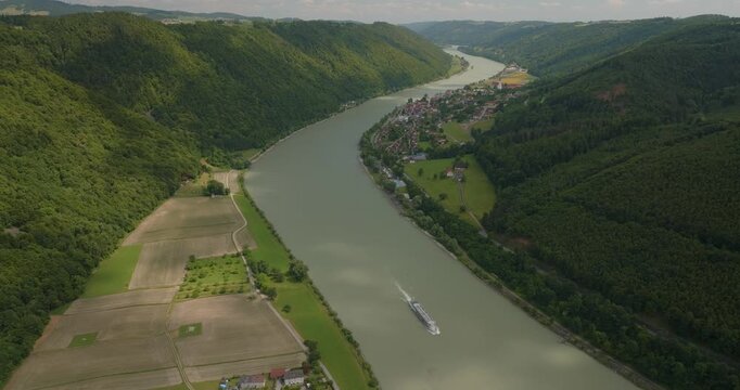 Beeindruckende Luftaufnahme der Donau sanften H&uuml;geln in Bayern. Panorama einer malerischen Flusslandschaft an einem sonnigen Sommertag.