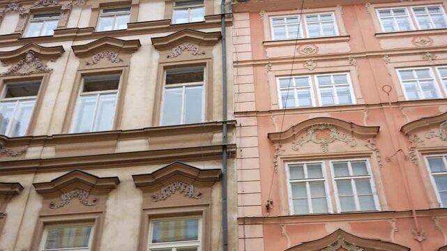 Residential facades show ornate stucco decorations and sculpted window surrounds in pastel Baroque architecture.