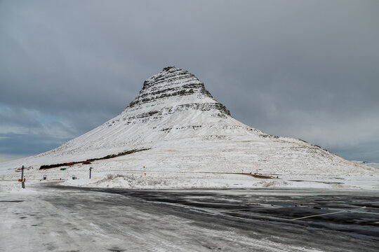 Kirkjufell mountain covered in snow under cloudy winter sky, Iceland