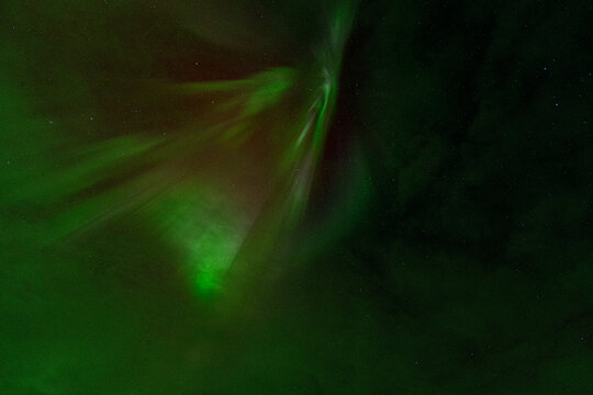 Abstract aurora borealis with green and red light in starry sky