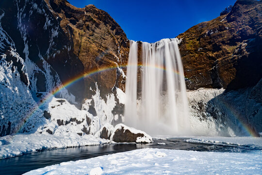Majestic Skogafoss waterfall with rainbow in winter, Iceland