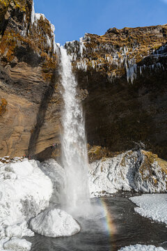 Kvernufoss waterfall in southern Iceland during winter with rainbow