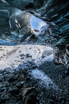 Beautiful blue ice cave interior with skylight hole opening to the sky in Vatnaj&ouml;kull National Park, Iceland