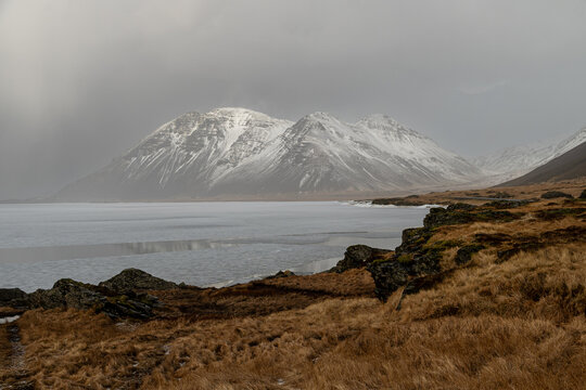 Scenic view of icy lake shore and snow covered peaks in Iceland