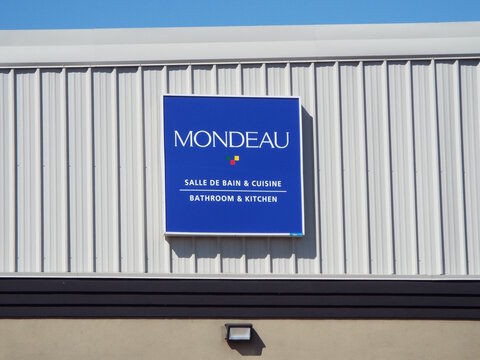 Gatineau,Quebec, Canada &ndash; May 17, 2026:A blue sign for "MONDEAU" displays salle de bain & cuisine and bathroom & kitchen on a building on Rue Jean-Proulx.