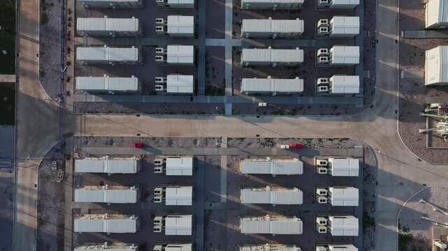 Aerial view of battery energy storage station with containerized battery arrays arranged in neat rows