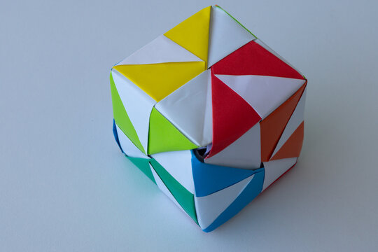 Child playing with colorful origami paper cube toy