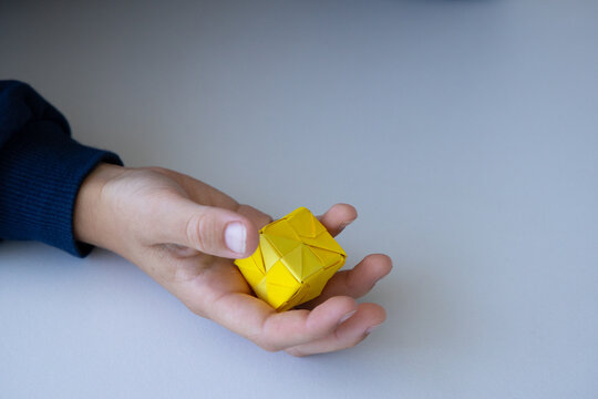 Child playing with colorful origami paper cube toy