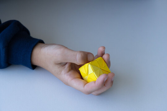 Child playing with colorful origami paper cube toy