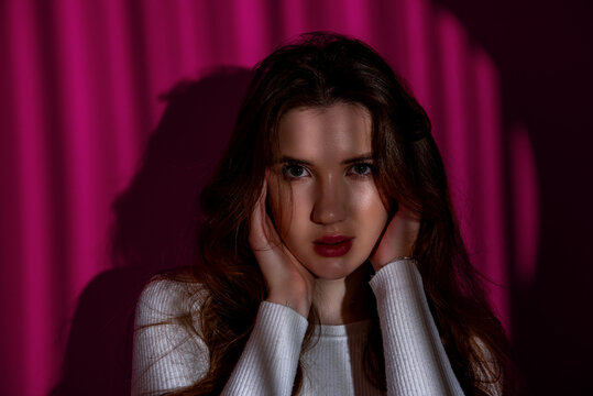 Woman portrait in studio, with shadow lines light and a purple background