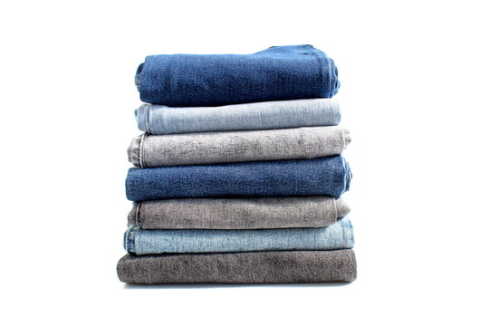 There is a stack of folded jeans on a white background.