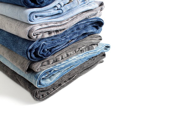 There is a stack of folded jeans on a white background.