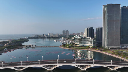 Modern cityscape of Rizhao Shandong featuring waterfront architecture bridges and high-rise buildings under clear blue sky © zhu difeng