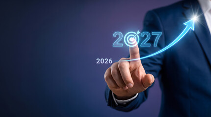 Obraz premium Business growth and strategy concept for 2027 with upward trend arrow, Future performance and target achievement in 2027. Businessman touching holographic graph.