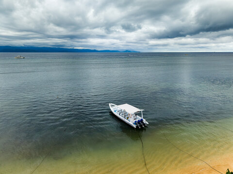 High angle view of a white motorboat moored in calm, shallow water near the shore