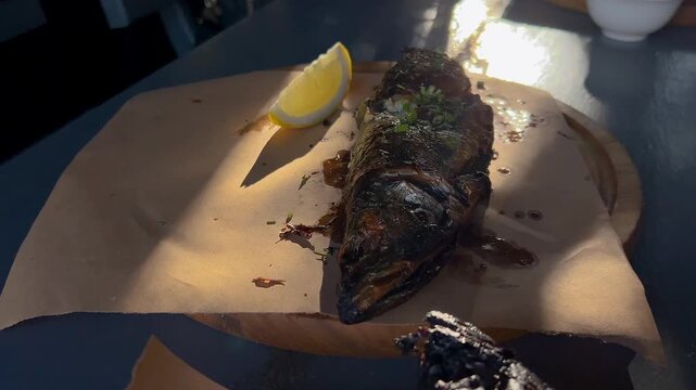 Grilled mackerel, fish barbecue with lemon. Fried mackerel on the table.