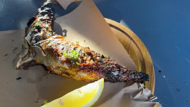 Grilled mackerel, fish barbecue with lemon. Fried mackerel on the table.