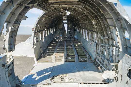 Interior view of a decommissioned aircraft fuselage showing empty cargo bay and structural framework,Solheimasandur Plane Wreck,Iceland