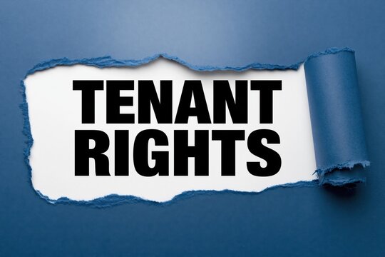 Tenant rights concept text revealed under a horizontal tear of dark blue paper