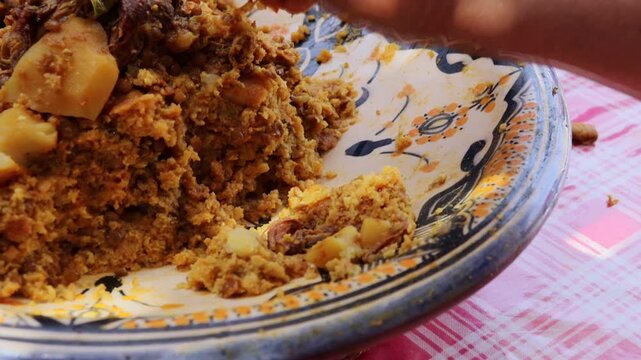 Eating traditional Moroccan trid with qaddid meat by hand
