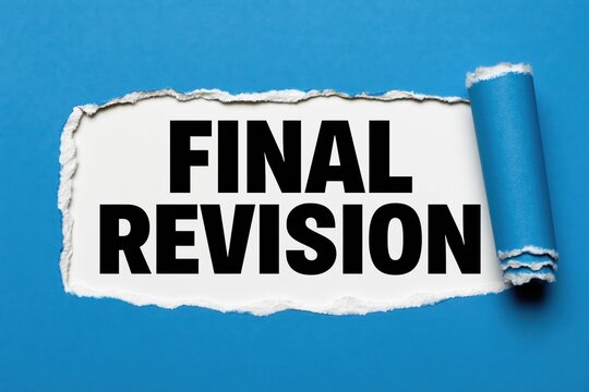 Conceptual words final revision written on white paper under torn dark blue paper