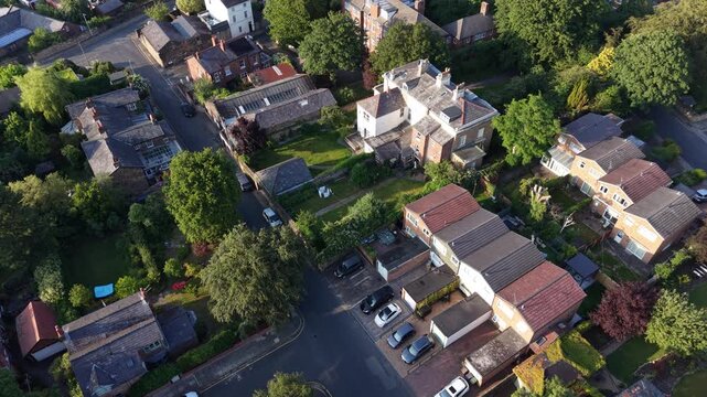Aerial drone 4K footage showing long rows of homes glowing beneath warm golden hour sky England