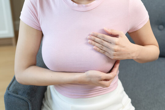 Close up of a woman doing breast self examination for cancer awareness.