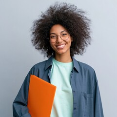 Obraz premium Cheerful young woman holding orange notebook for education portrait and student profile background for study banner and learning materials