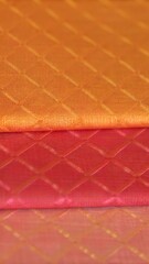 Fototapeta premium Orange and pink satin quilted fabric texture with diamond pattern