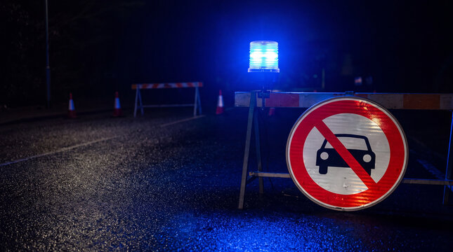 Roadblock warning blue beacon light no entry sign dark road traffic barrier night street warning signal blocked road safety control emergency light