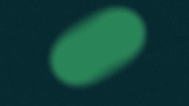 Blurry green circle against dark background with colorful dots
